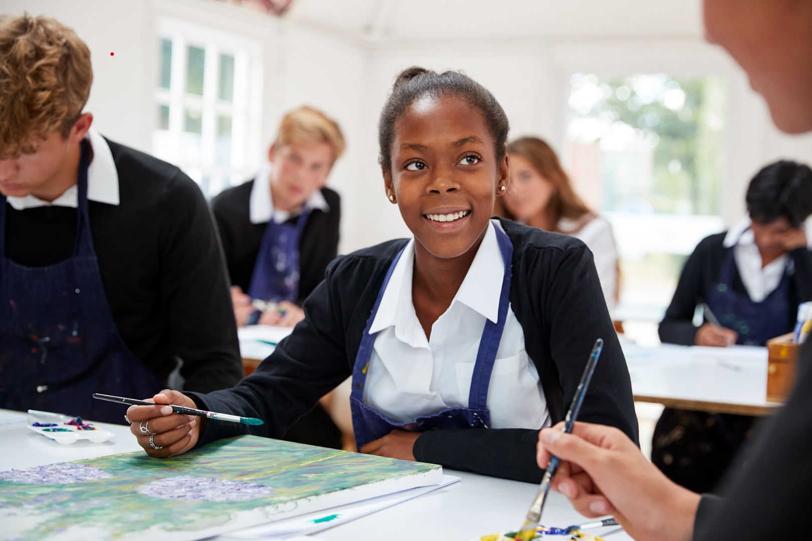 Young girl smiling in art class at school