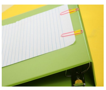 Green ring binder on yellow background